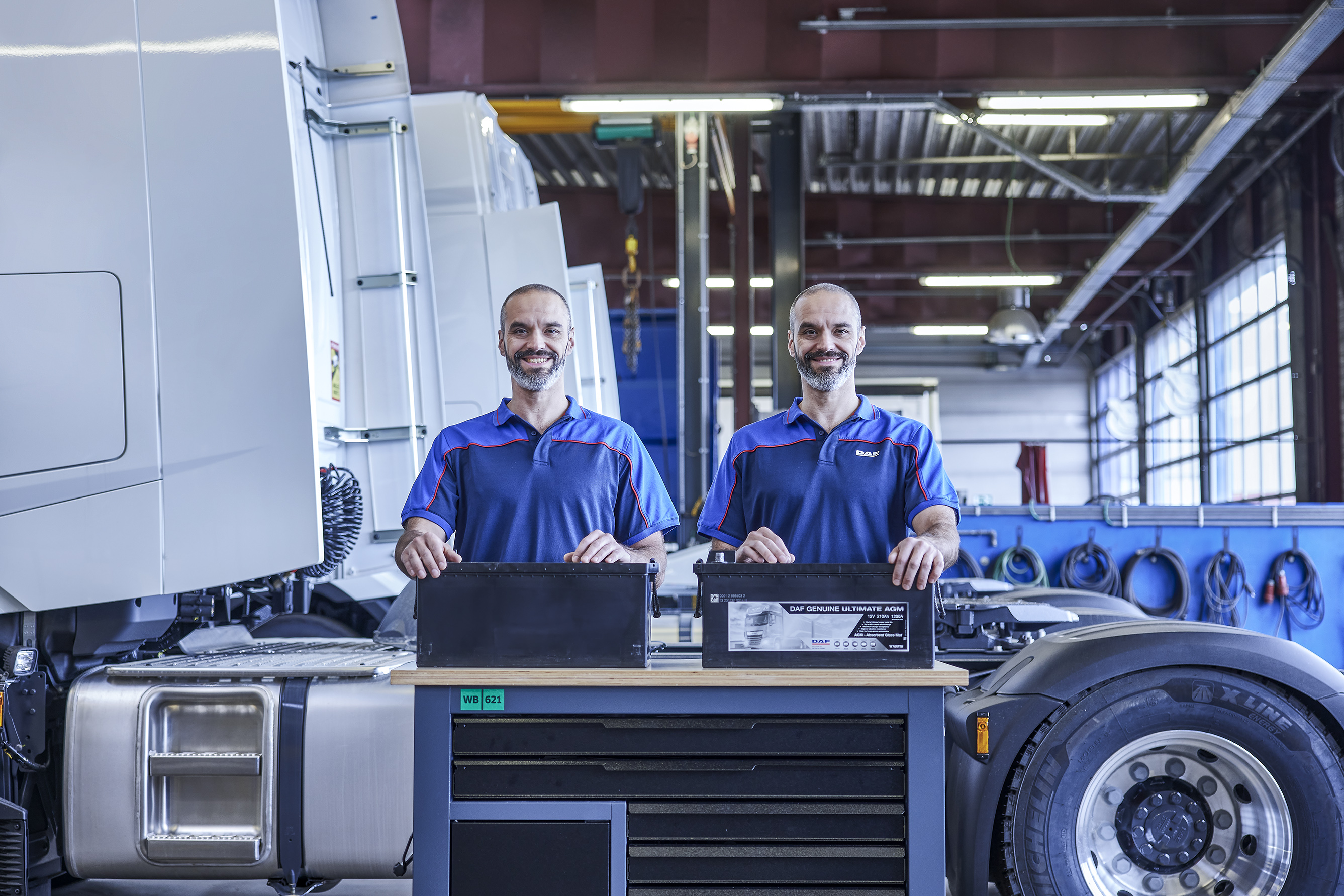 Twin mechanics in DAF workshop holding DAF Genuine Ultimate AGM batteries